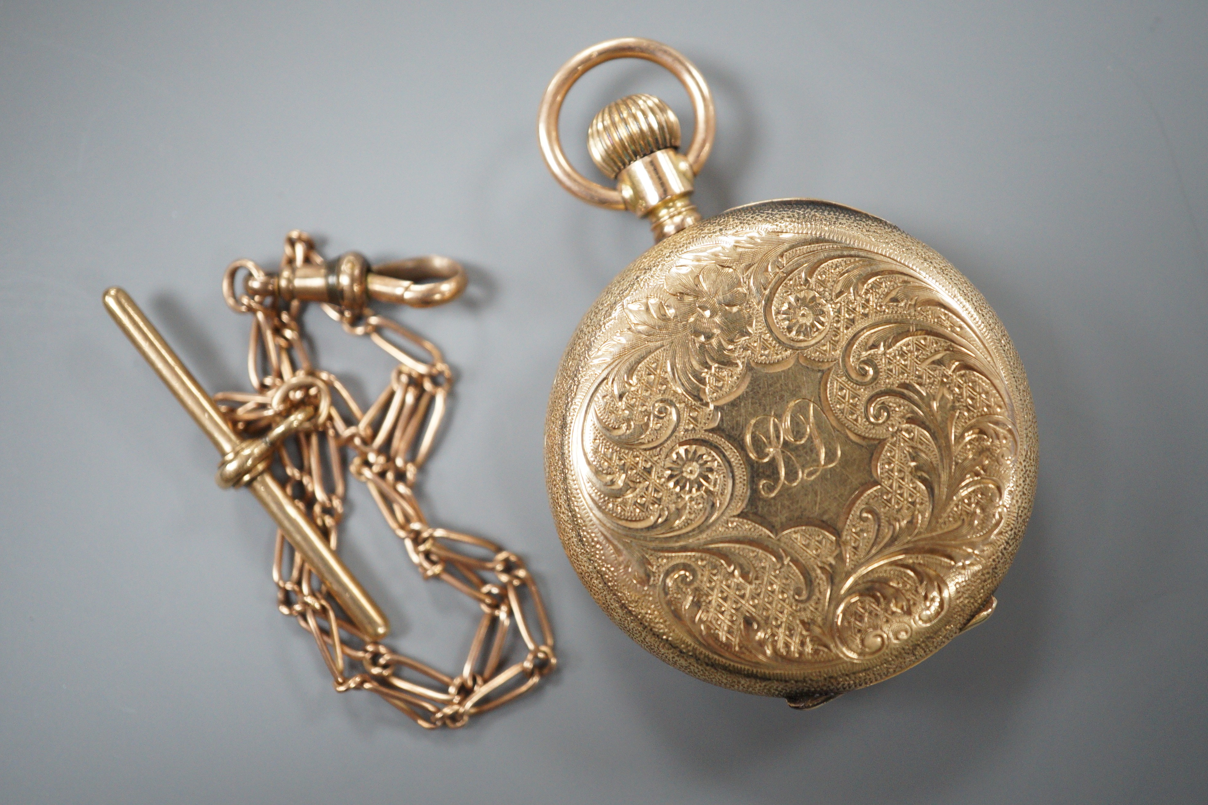A gentleman’s 10C yellow metal Waltham open faced keyless pocket watch, gross 45.7 grams, on a 9ct gold albert, 6.3 grams.